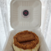 Biscoff cheesecake in takeaway box topped with lotus biscoff biscuit and crumbs