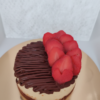 Chocolate cheesecake topped with fresh strawberries and chocolate drizzle