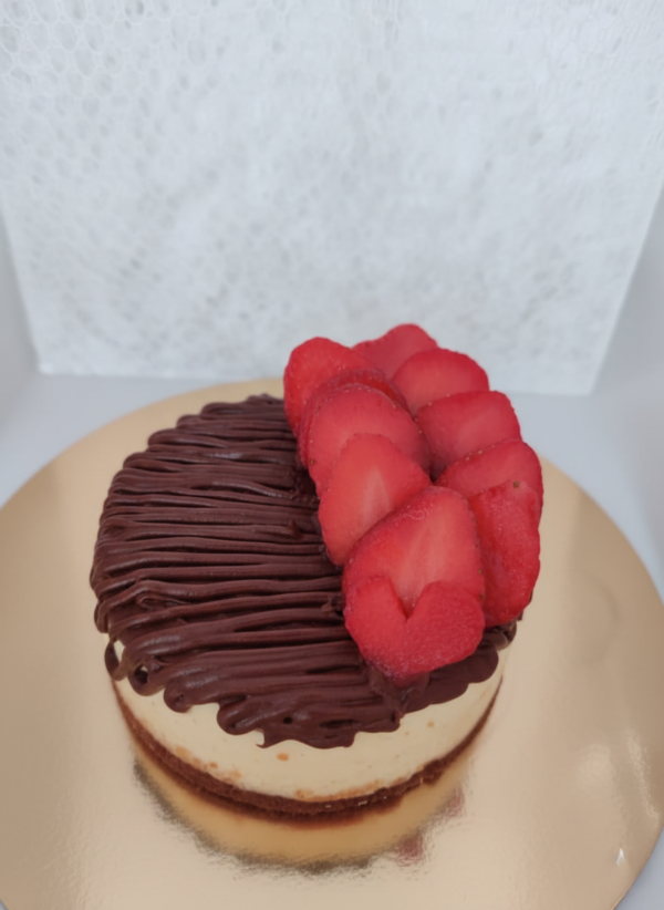 Chocolate cheesecake topped with fresh strawberries and chocolate drizzle